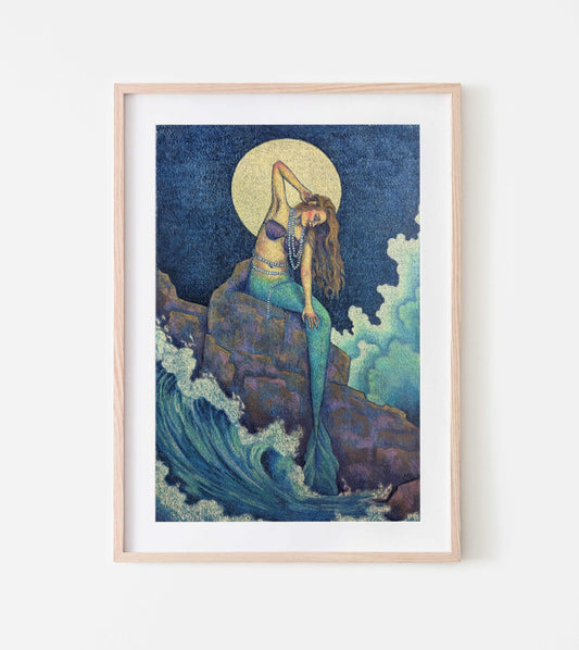 Art print depicting a mermaid resting on a rocky shore, gazing out over waves under a full moon
