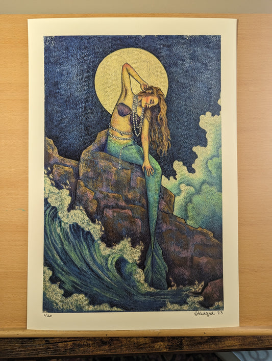 A limited edition fine giclee art print of a mermaid sitting on rocks under a full moon surrounded by ocean waves