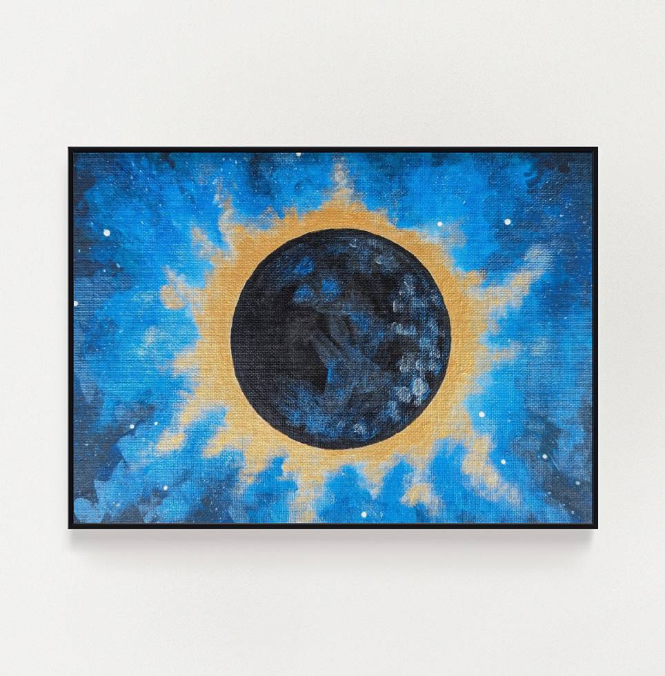 A framed eclipse art print depicting the sun’s corona glowing brightly against a dark sky