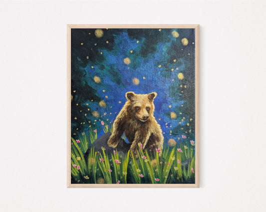 Art print of a brown bear cub sitting in a meadow filled with pink flowers in summer under a glowing sky with fireflies
