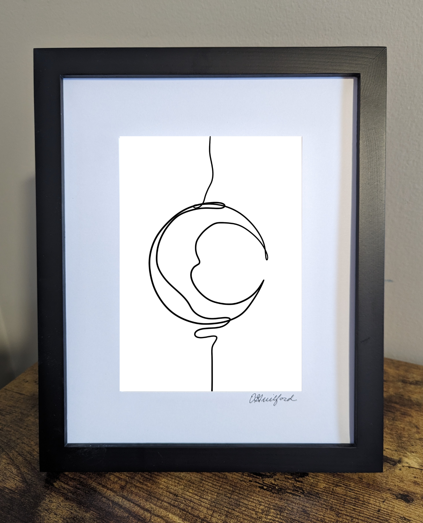 Art print with a minimalist black line drawing of a crescent moon creating an artistic representation of the moon's shape