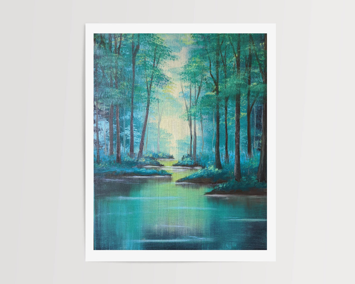 A tranquil framed art print depicting tall trees alongside a calm river illuminated by soft sunlight filtering through the trees