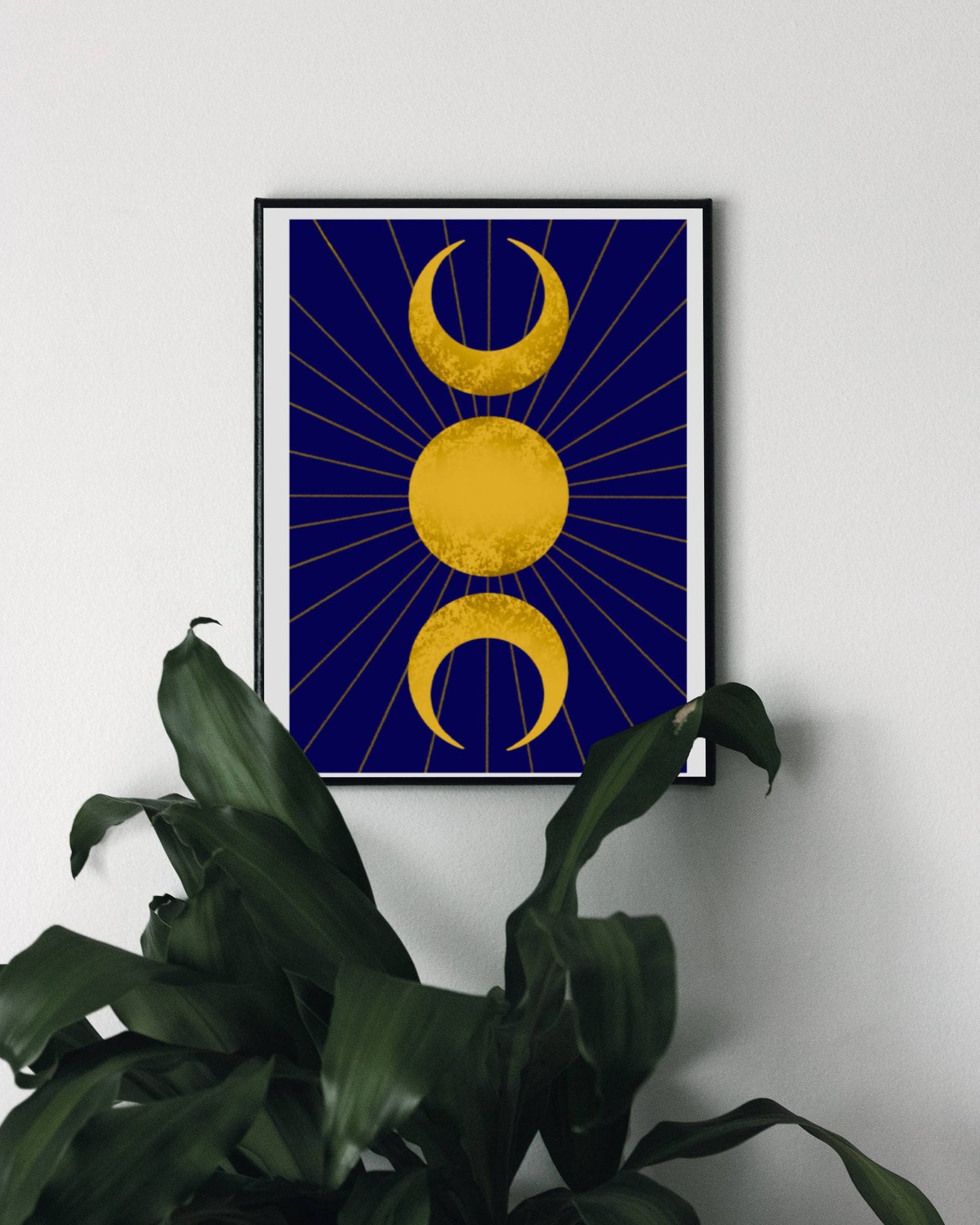 A celestial art print featuring the triple moon symbol, with two crescent moons flanking a full sun all in gold