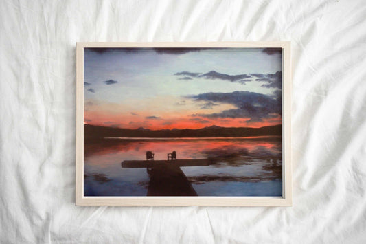 Art print of tranquil sunset scene over a small lake with two chairs placed at the end of a dock