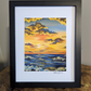 Art print of vibrant sunset over the ocean with waves gently crashing onto the shore decorated with golden clouds in the sky