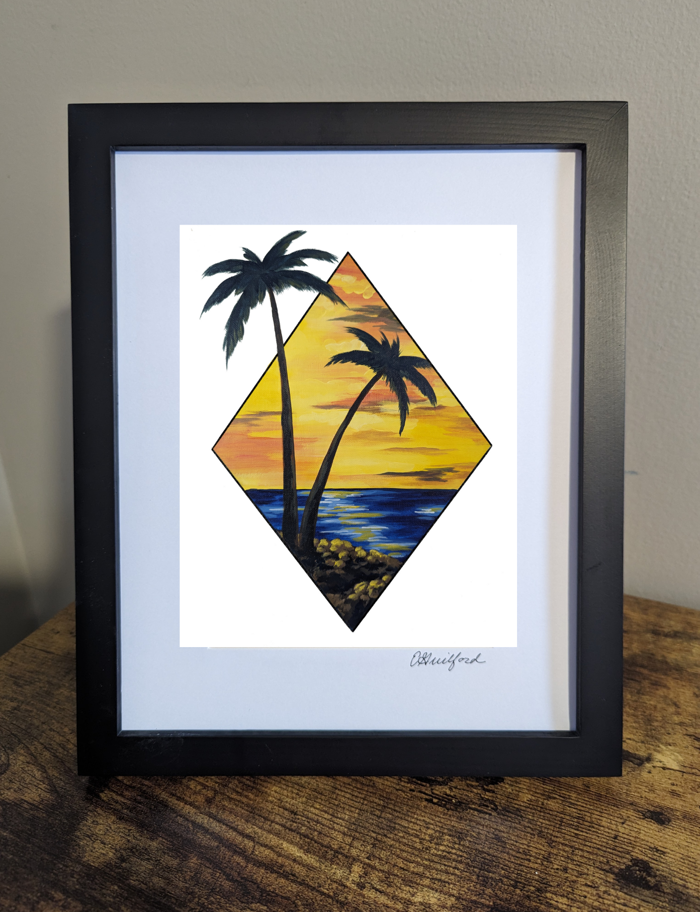 Framed art print featuring a scenic view of two palm trees by the water at sunset