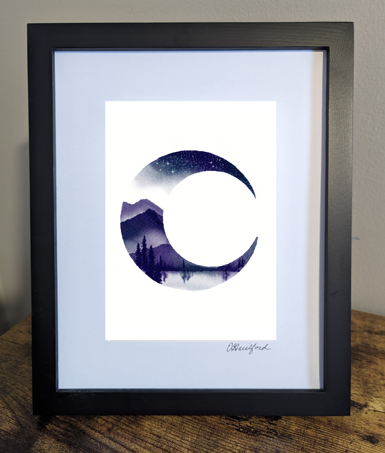 Art print of the crescent moon with a mountainous landscape, a lake, and pine trees filling the crescent shape