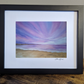 Art print of a beautiful purple sunset over a tranquil beach with soft purple, navy and pink hues in the sky