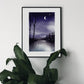 Art print of a night scene with the waning gibbous moon shining above a calm lake surrounded by silhouetted trees and mountains in the distance